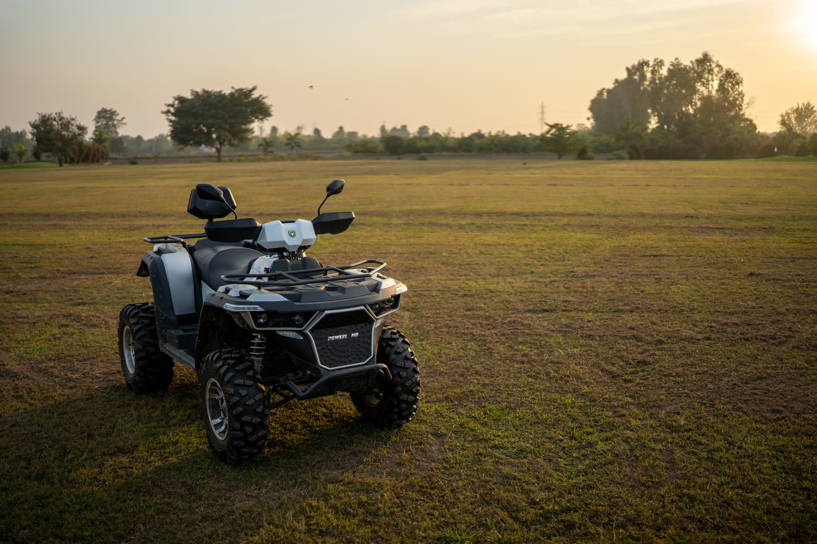 An ATV on the grass at sunset