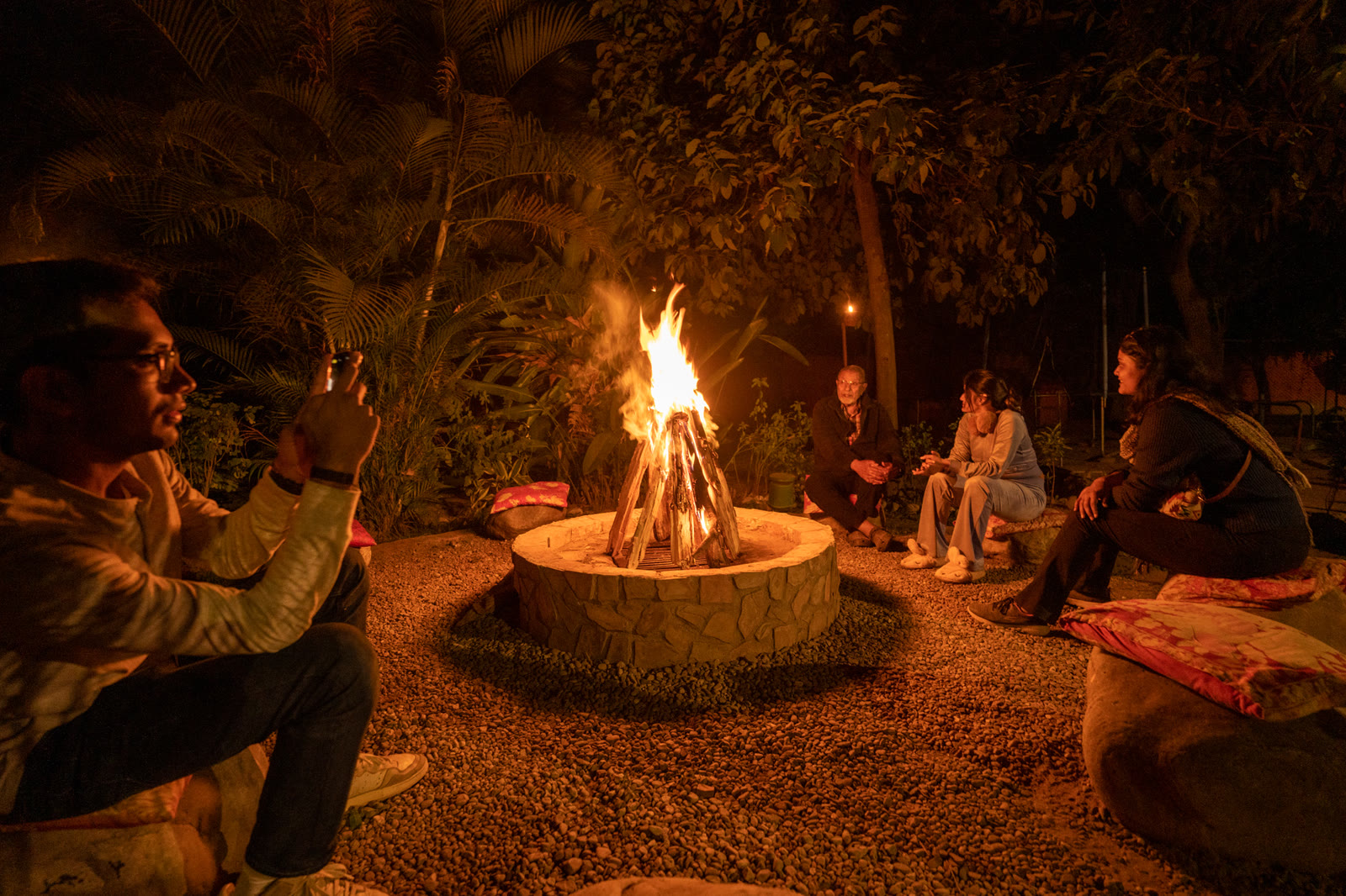 Guests round the fire pit at night