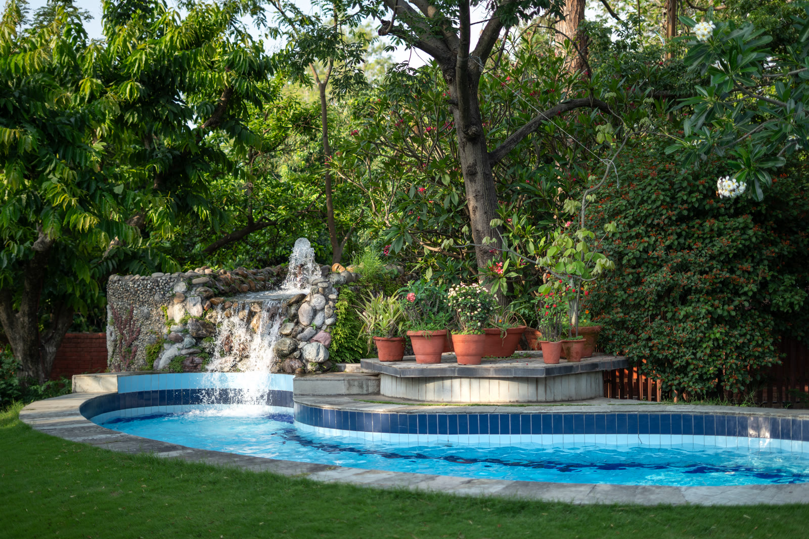 The swimming pool and its stone waterfall in the garden