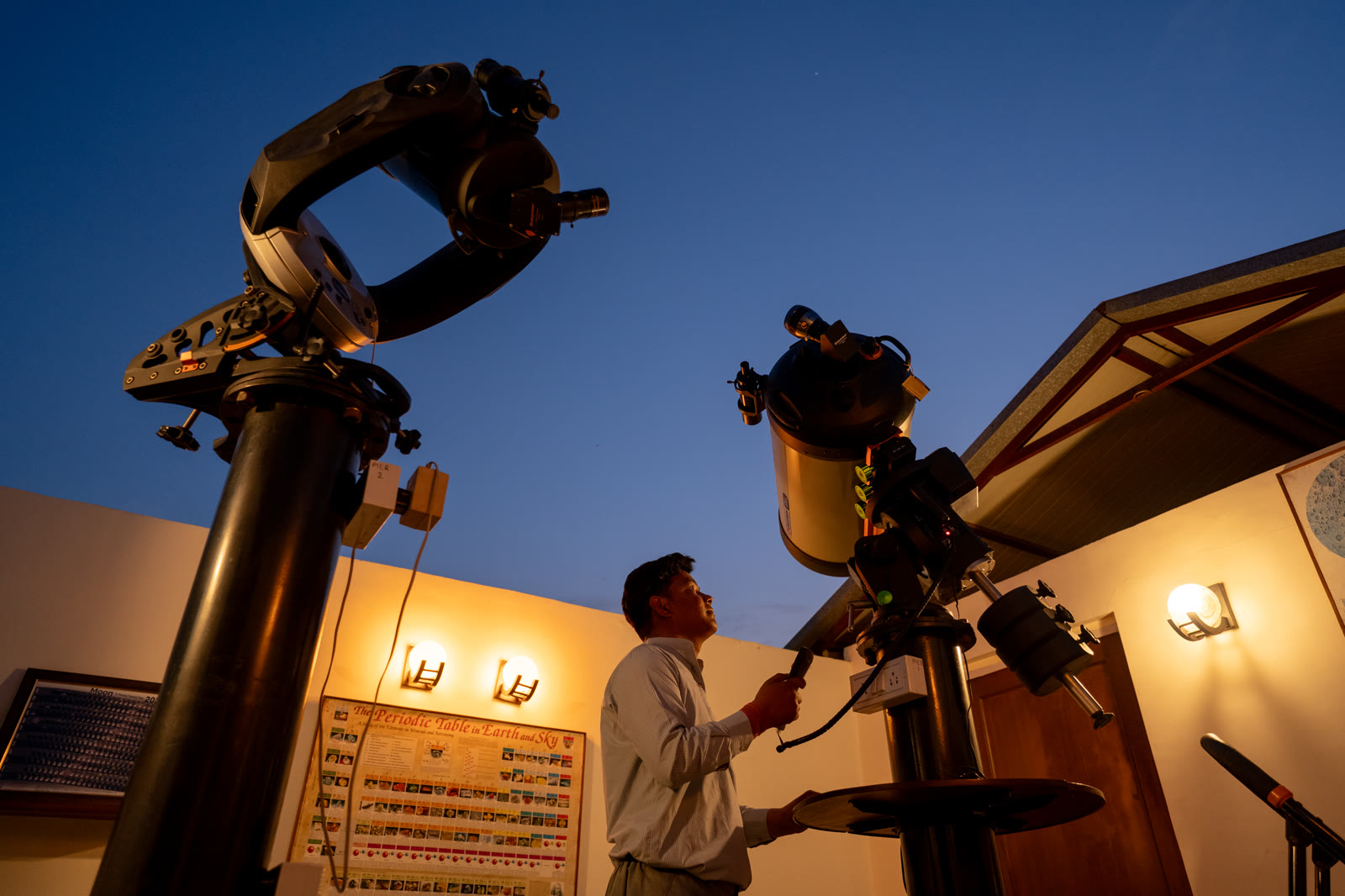 A man at the telescopes at TARA, the farm's observatory, at dusk