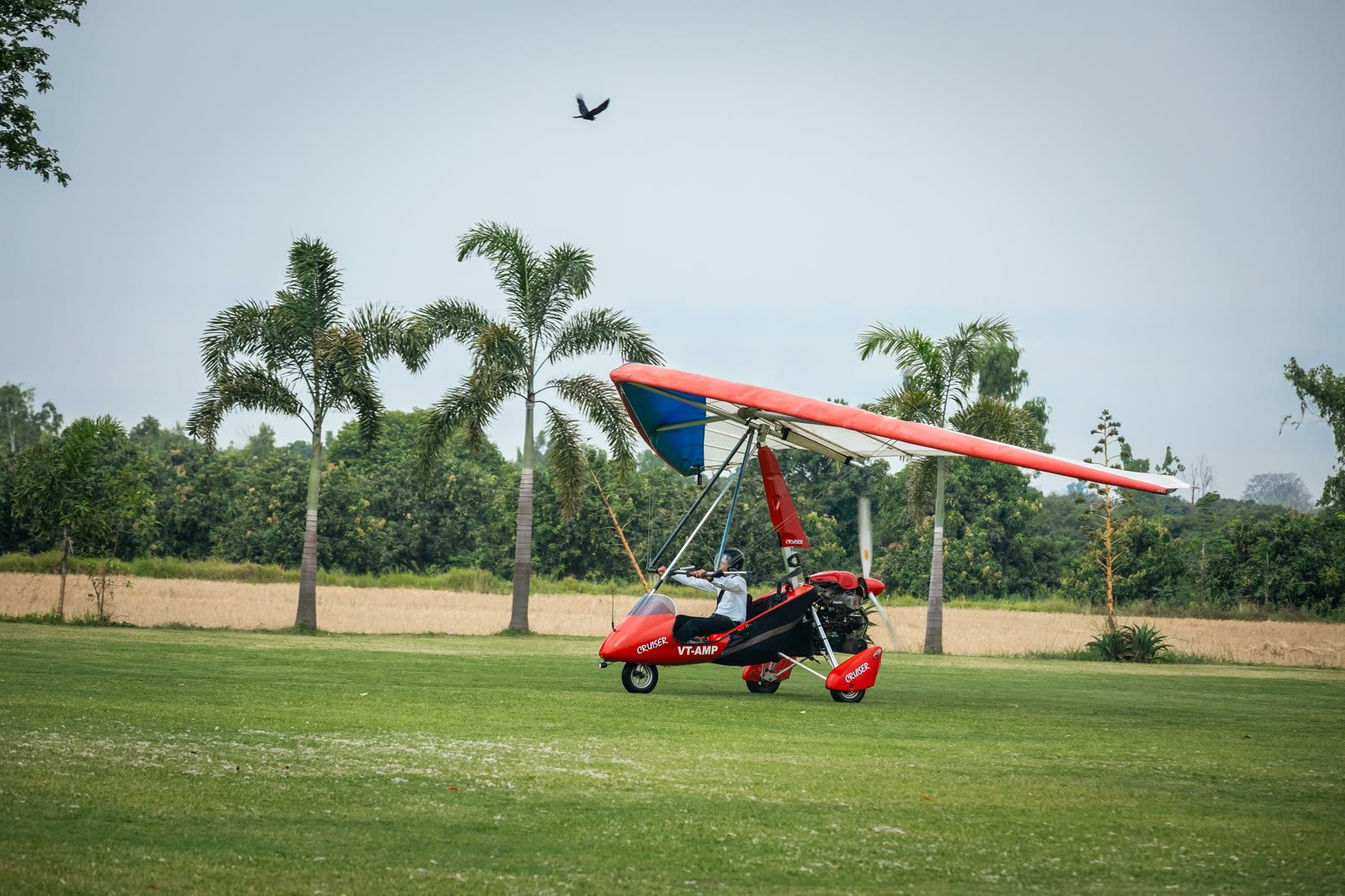 The red ultralight trike on the grass runway at Sakhanpur Airfield